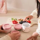 Gyermek és felnőtt pakolja a gyümölcsöket és nasit a kinyitott Little Dutch Fairy Garden dobozokba