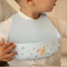 Kisgyermek nyakában Little Dutch Forest Friends szilikon előke etetés közben