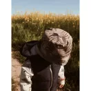 Toddler felülnézetből a sárga virágos mezőn a Makaszka Funky monkey majommintás sapkájában