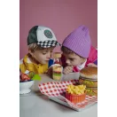 Két kisgyermek kíváncsian nézi a Petit Boum MacBoum palackot az asztalnál
