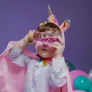 Kisgyermek néz keresztül a fektetett Petit Boum Rainbow unikornisos palackon