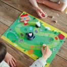Egy gyermek és egy felnőtt játszik a fából készült asztalon elhelyezett Djeco Woolfy társasjátékkal