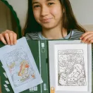 Kislány mutatja a Kidywolf átvilágítós rajztáblán készült kiszínezett rajzát