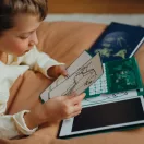 Gyermek nézegeti a Kidywolf Kidydraw Mini rajztáblához tartozó átmásolható mintakártyákat