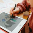 Gyermek kéz Kidydraw Mini LCD táblára rajzol színes vonalakkal és ceruzával