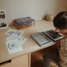Gyermek rajzol a Kidywolf 8.2 colos LCD kijelzős rajztábláján a mellékelt mintakártyák alapján