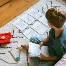 Gyerek rajzol a földön a Kidywolf Kidydraw Pad 6 mintalapjaival