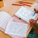 Gyermek rajzol a Kidywolf Kidydraw Pad világító táblán a mesevilág sablon segítségével