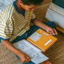 Gyermek a Kidywolf Kidydraw Pad 8 lovas mintafüzetet használja rajzolás közben