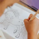 Gyermek unikornis mintát rajzol körbe a Kidydraw Pad világító táblán