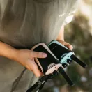 Két Kidywolf walkie talkie kézben tartva a szabadban zöld természetes háttérrel