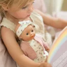Fekvő Little Dutch Philou baba lecsukódott szemekkel a virágmintás fekhelyen
