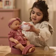 Little Dutch Livia itatós-pisilős baba virágmintás rózsaszín pamutruhában és fejpánttal