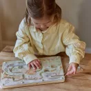 Kislány az asztalnál játszik a Little Dutch szafari mágneses labirintussal