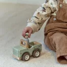 Kisgyermek kezében a Little Dutch szafári autó figurája beültetés közben