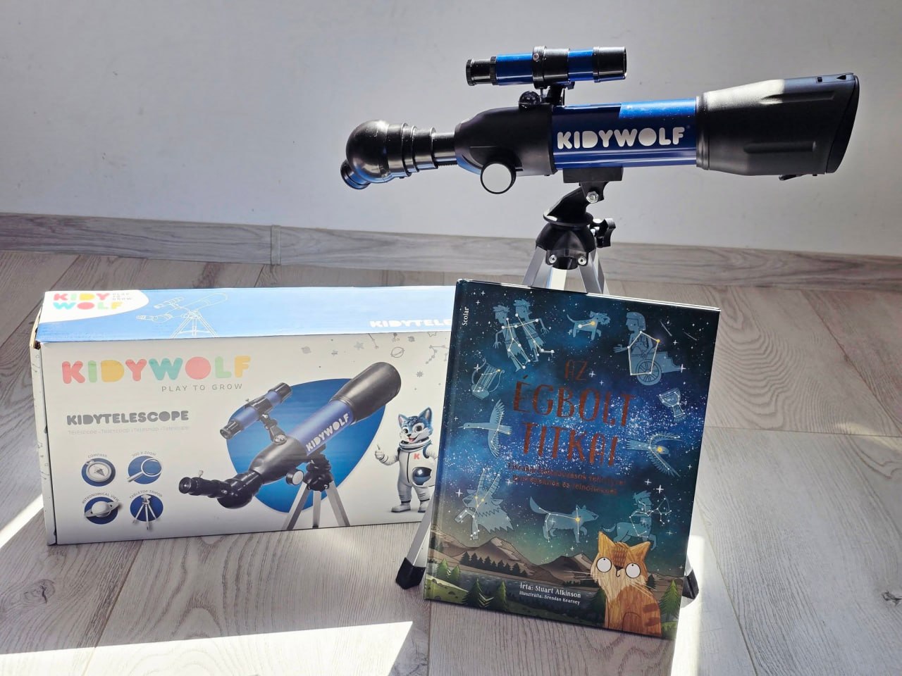 A Kidywolf Kidytelescope összeszerelve, mellette a doboza és Az égbolt titkai című könyv, Fruzsina saját fotóján