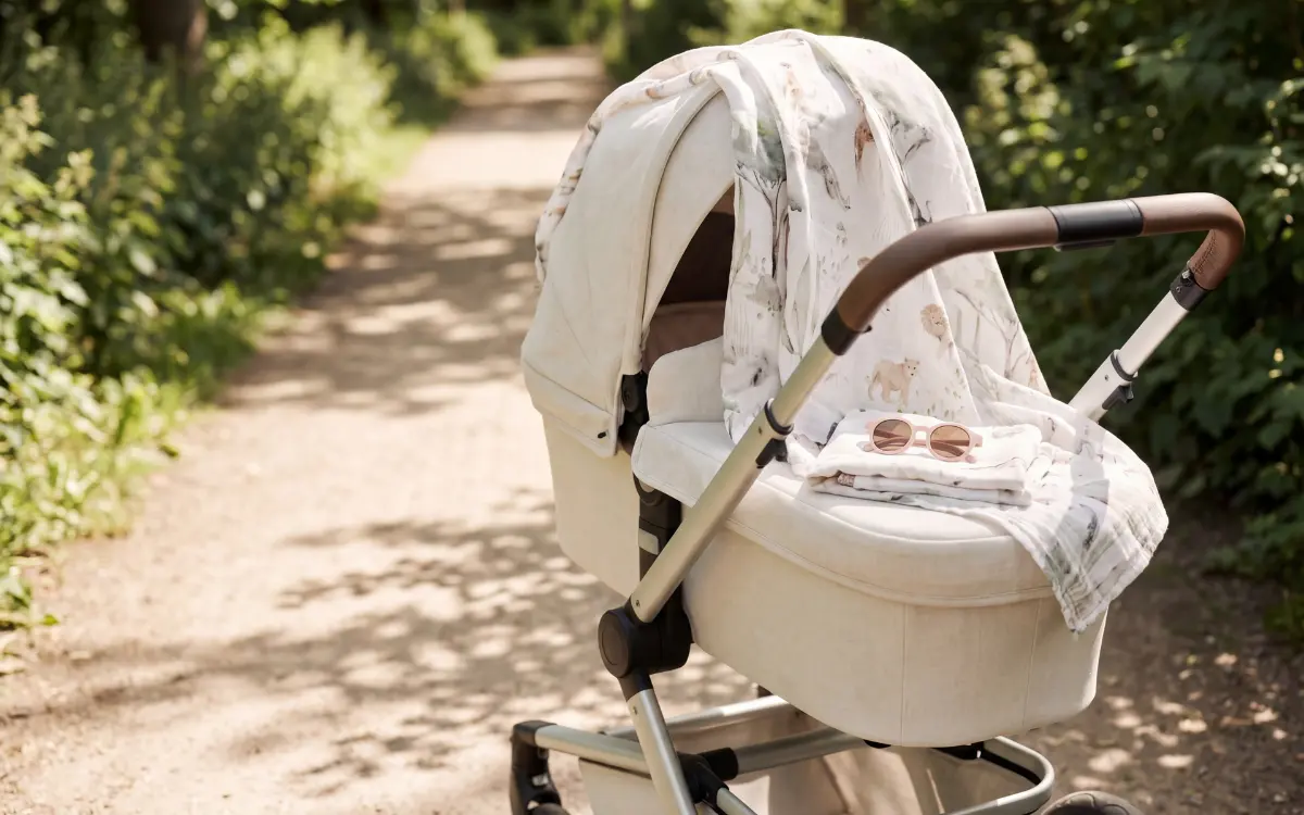 Baba babakocsiban napszemüvegben és UV-muszlinnal – teljes napos védelem