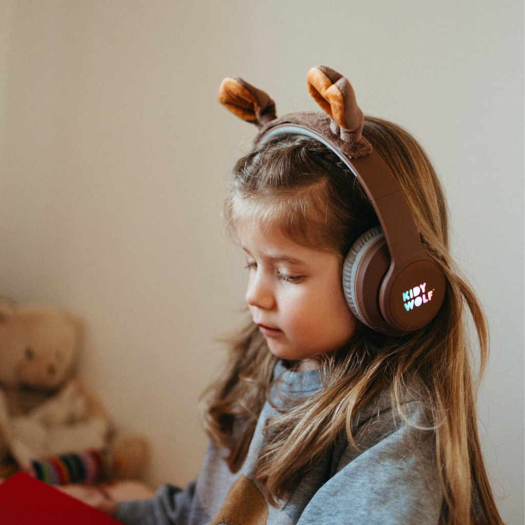 Kislány a barna, macifüles Kidywolf Kidyears bluetooth fejhallgatóval a fején
